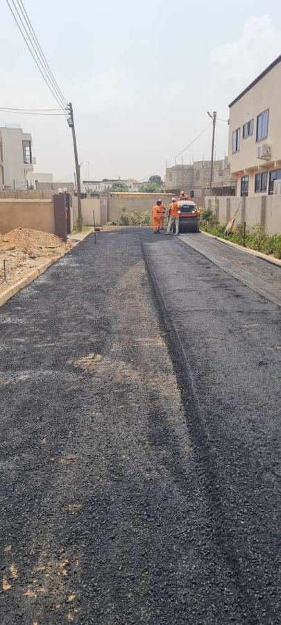 Worker paving a road with fresh asphalt